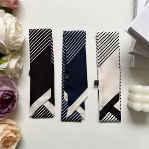 Detailansicht von drei gestreiften Twilly-Schals aus Satin mit Dekoration und Blumenelementen