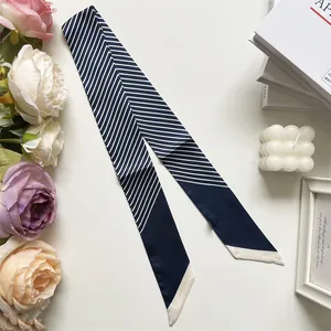 Nahaufnahme des blau-weiß gestreiften Seidenschals mit eleganten Lifestyle-Requisiten