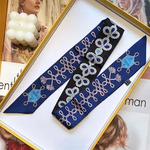 Detail of silk twilly scarf with rope print and France Paris text in a gift box