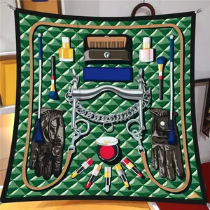 Flat lay of a 90cm square silk scarf featuring green geometric patterns and beauty tools