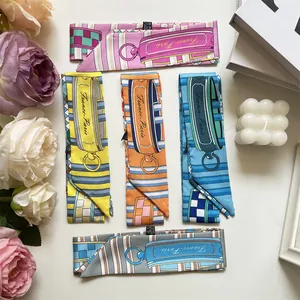 Detail view of colorful printed silk-like twilly scarves with France-Paris text patterns