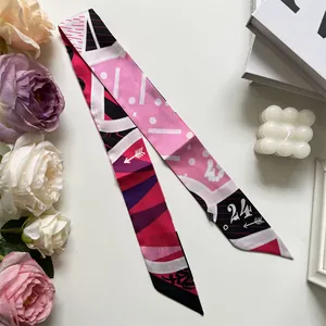 Detail of pink and purple geometric twilly silk scarf with number 24 print on silk ribbon