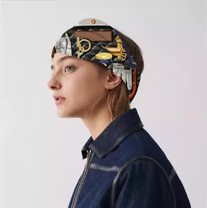 Detail of silk-feel scarf with gold chain and buckle patterns on model hair