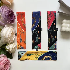 Close-up of printed silk scarfs in multiple colors with luxury chain and tassel patterns
