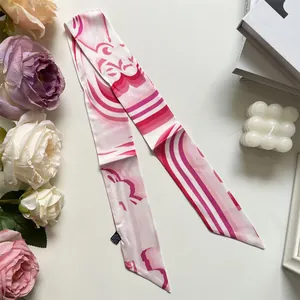 Detail of pink abstract print silk twilly showing satin texture and diagonal cut ends