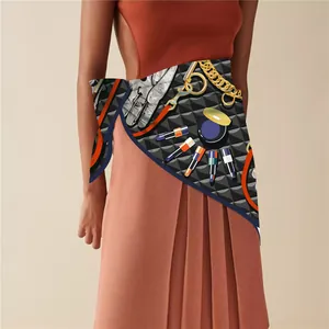 Detail of artistic print silk scarf styled as a waist accessory on an orange pleated dress