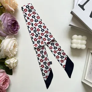 Détail macro du foulard twilly avec motif mors et pointes noires élégantes