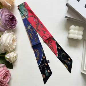 Macro detail of silk scarf featuring gold key pattern, chains, and laundry care label