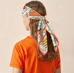 Detail of silk-feel scarf with equestrian motifs worn as an elegant hair accessory
