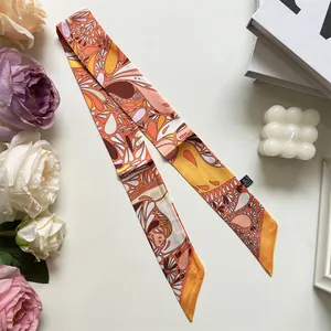 Detail view of a vintage paisley silk scarf with dry clean label on white backdrop