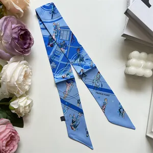 Detalle de un pañuelo Twilly de seda azul con motivos de París y decoraciones florales