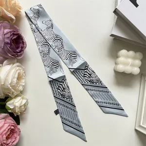 Detail of silk-like blue zebra print twilly scarf with elegant floral props background