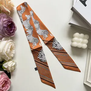 Detailed macro view of orange and zebra print silk scarf with floral background
