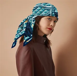 Detail of blue and white geometric silk headscarf with bridle print on a model