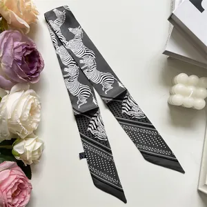 Detailed flat lay of zebra print silk twilly scarf styled with roses and decor