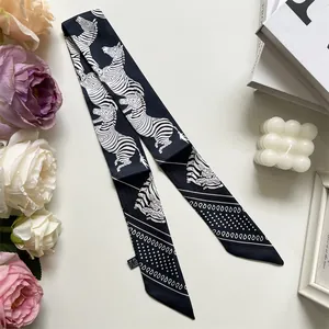 Close-up of a black and white zebra pattern silk twilly scarf with elegant brand tag