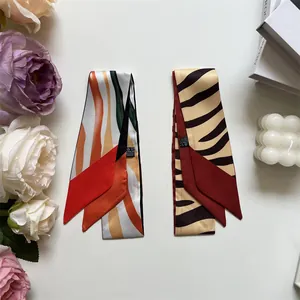 Close-up of zebra pattern and colorful abstract print silk scarves for handbags