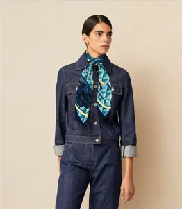 Detail of silk-feel scarf with geometric patterns in navy blue and yellow tied as neckerchief