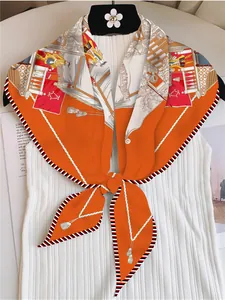 Detail eines schicken Seidenschals in Orange mit eleganten Palastmustern