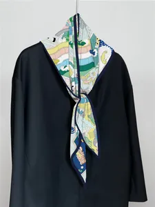 Detail view of a luxury silk scarf with nautical prints and navy blue contrast borders