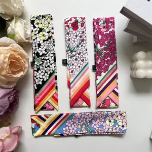 Flat lay of floral pattern skinny silk scarves with striped ends and decorative props