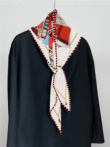 Detail eines Seidentuchs mit klassischem Kutschenmuster und Streifenrand auf einer Jacke