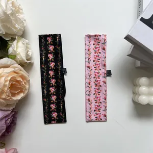 Detailansicht von Blumen-Haarbändern aus Seide mit Pflegeetikett auf weißem Tisch