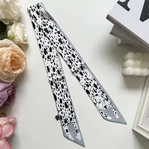 Detail of dalmatian print skinny scarf with cute dog illustration on white background