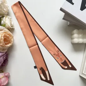 Detail of pink silk scarf with cute bunny print, brown edges and smooth satin texture