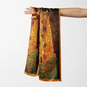 Détail macro du foulard en soie avec l'imprimé Le Baiser de Klimt et bordure en satin orange
