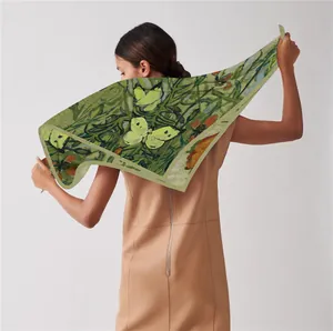 Macro view of green silk scarf with Van Gogh style butterfly and plant pattern