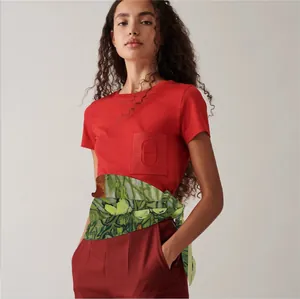 Detail of artistic painted silk scarf paired with red Hermès style embroidered t-shirt