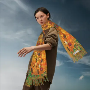 Artistic cashmere pashmina with The Kiss print and tassels against a blue sky background