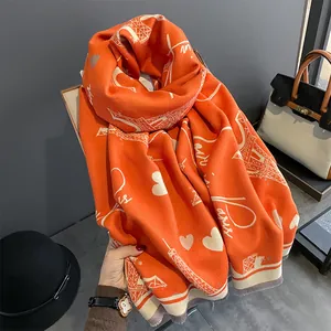 Bright orange cashmere shawl featuring white Eiffel Tower Paris prints and fringes