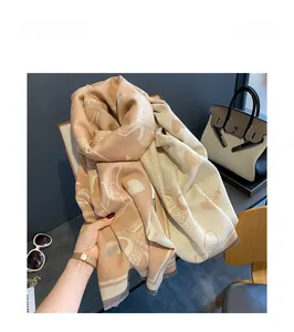 Close-up of peach pink jacquard scarf with Eiffel Tower prints and tassel edges