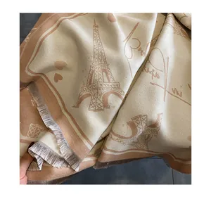 Close-up of cashmere-feel scarf detailing the Eiffel Tower pattern and soft fringe edges