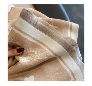 Macro detail of high-quality cashmere scarf featuring soft fringe and jacquard heart patterns
