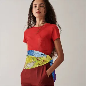 Detailed view of artistic oil painting silk scarf styled with a red H-logo pocket t-shirt