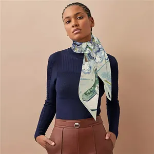 Detail view of premium silk scarf with artistic blue floral print on fashion model