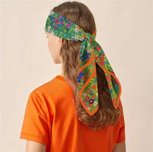Close-up of vibrant floral silk scarf tied as a headband over loose wavy hair
