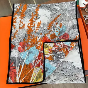 Artistic floral silk scarf with vibrant prints displayed in a premium orange gift box