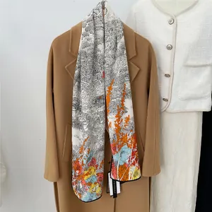 Detail of silk crepe de chine scarf with landscape print draped on a wool coat