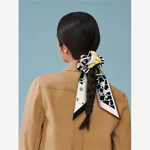 Elegante lazo de seda para el pelo con cintas florales largas en una coleta trenzada