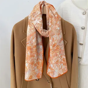 Elegant floral print scarf in orange and cream with hand-stitched rolled edges