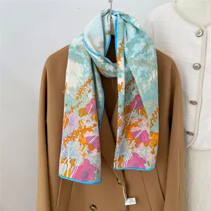 Floral print 100% mulberry silk scarf in light blue paired with a wool coat