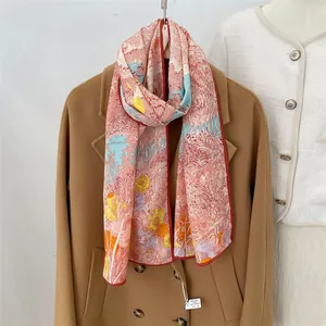 Floral print winter scarf in coral and blue draped over premium coats for women