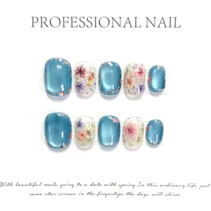 Blaues Katzenaugen-Nagelset mit Blumenmustern und Goldfolie auf weißem Hintergrund