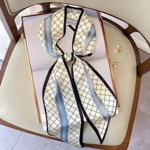 Elegant narrow twilly silk scarf with diamond patterns on an open book background