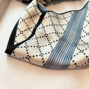 Close-up of silk scarf fabric showing polka dot diamond pattern and blue stripes