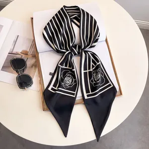 Elegant long black and white striped silk scarf with rose pattern tied in a bow